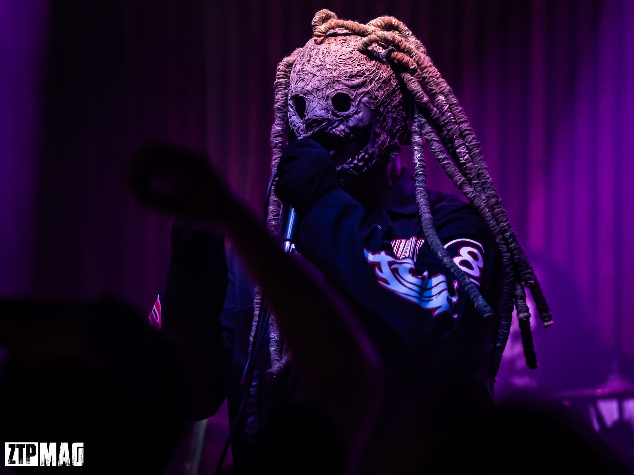 Solo performer wearing the 25th Anniversary mask with dreadlocks